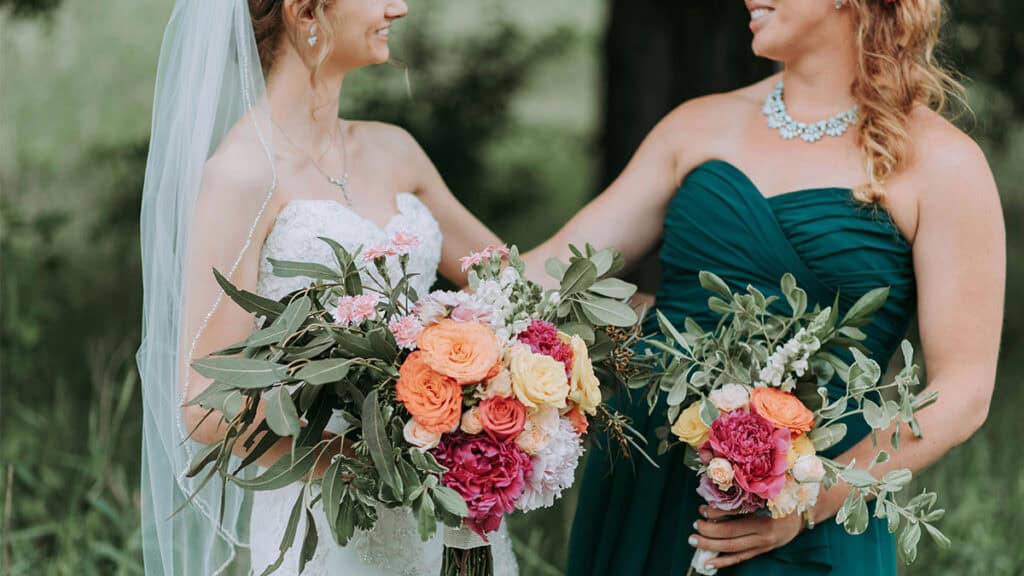 Smaragdově zelené šaty pro družičku laděné se svatební kyticí – moderní svatební trendy roku 2026